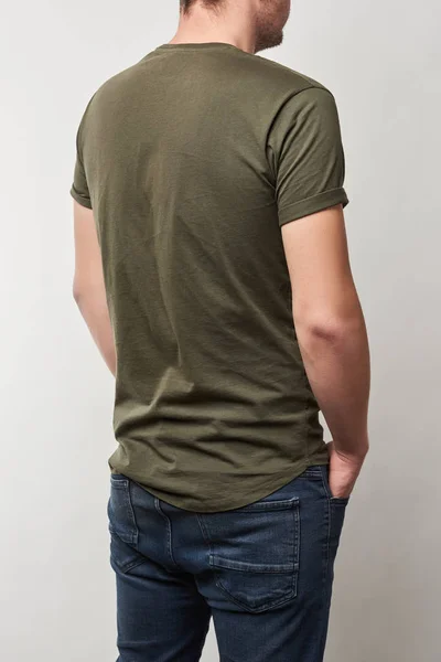 Vista trasera del hombre en camiseta caqui con espacio de copia aislado en gris - foto de stock