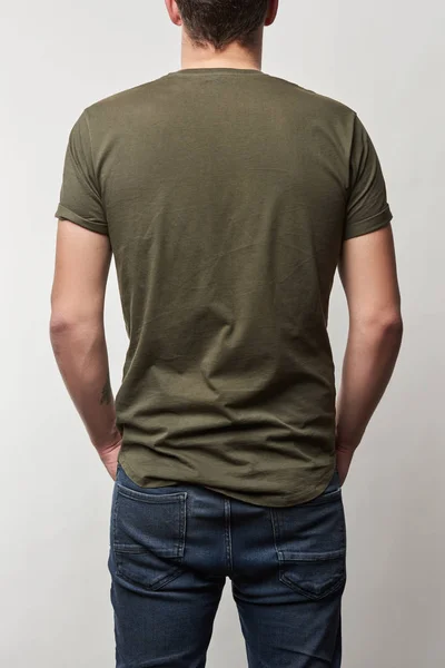 Vista trasera del hombre en camiseta caqui con espacio de copia aislado en gris - foto de stock