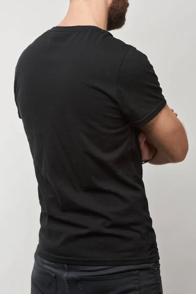 Rückansicht eines Mannes in schwarzem Baumwoll-T-Shirt mit Kopierraum isoliert auf grau — Stockfoto