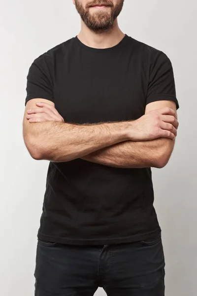 Cropped view of bearded man with arms crossed in black t-shirt with copy space isolated on grey — Stock Photo