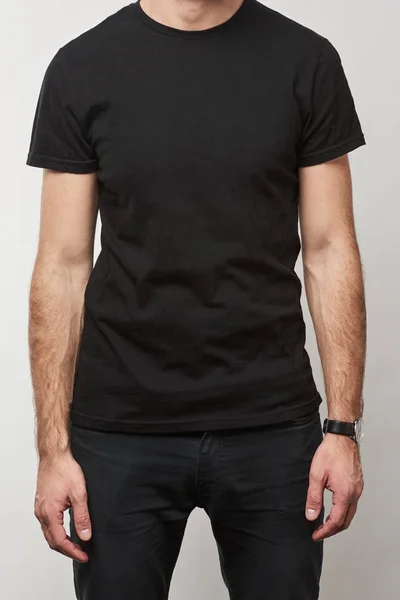 Vista parcial del hombre en camiseta negra con espacio de copia aislado en gris - foto de stock