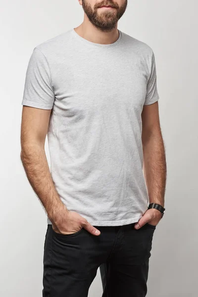 Vista ritagliata dell'uomo con le mani in tasche in t-shirt bianca con spazio copia isolato su grigio — Foto stock