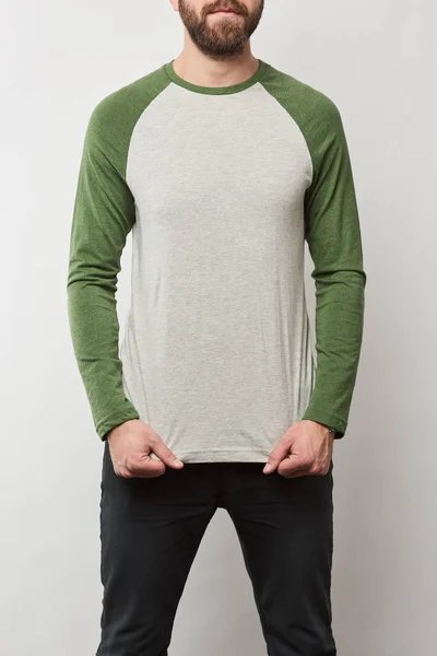Частичный вид человека в основной рубашке Raglan рукав бейсбол с копировальным пространством изолированы на сером — стоковое фото