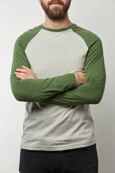 Partial view of man with arms crossed in raglan sleeve baseball shirt with copy space isolated on grey — Stock Photo