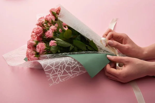 Plan recadré de femme enveloppant de belles roses tendres sur rose — Photo de stock