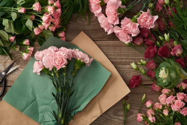 Draufsicht auf wunderschöne verschiedene Blumen, Bastelpapier und Scheren auf Holzoberfläche — Stockfoto
