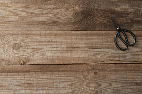 Vista superior de tijeras sobre fondo marrón rústico de madera - foto de stock