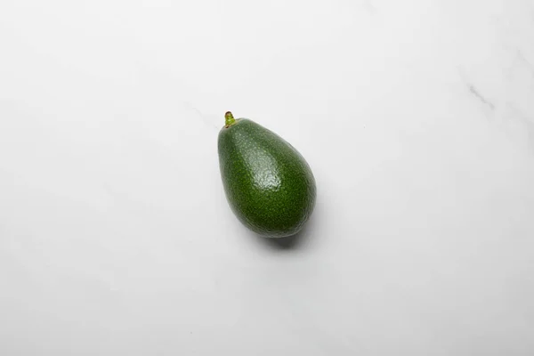 Top view of whole avocado on grey textured background — Stock Photo