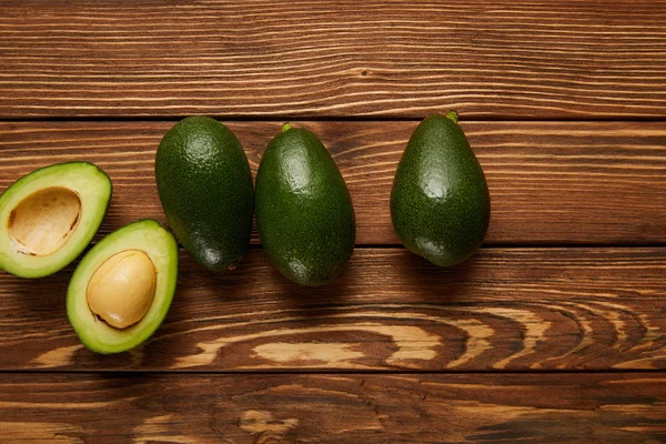 Top view of avocados on wooden background — Stock Photo