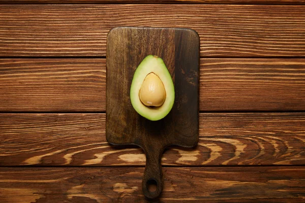 Vista dall'alto di avocado tagliato su sfondo di legno — Foto stock