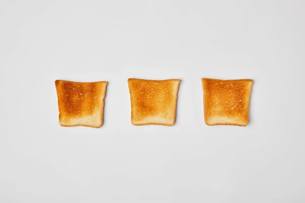 Top view of grilled crispy toasts on grey background — Stock Photo
