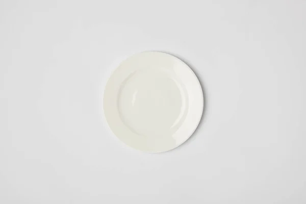 Top view of porcelain plate on grey background — Stock Photo