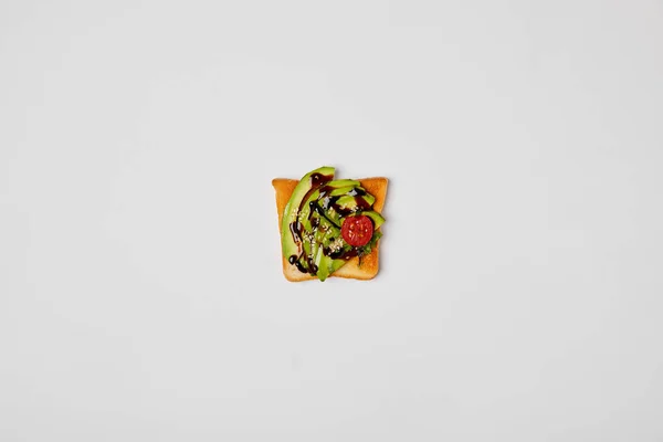 Top view of toast with avocado and cherry tomato on grey background — Stock Photo