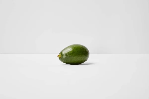 Enfoque selectivo de aguacate entero sobre fondo gris - foto de stock