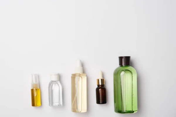 Vista superior de diferentes botellas de cosméticos sobre fondo blanco con espacio de copia - foto de stock