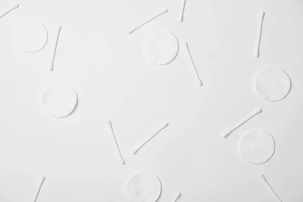 Vista superior de almofadas cosméticas e palitos de algodão no fundo branco — Fotografia de Stock