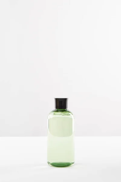 Garrafa cosmética transparente com tônico no fundo branco com espaço de cópia — Fotografia de Stock