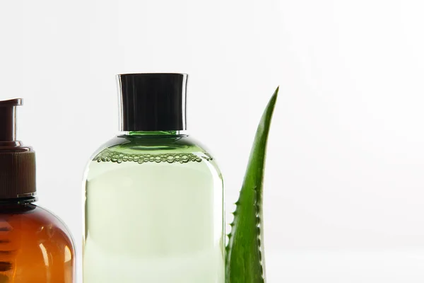 Kosmetikspender mit Lotion und Flasche Serum auf weißer Oberfläche — Stockfoto