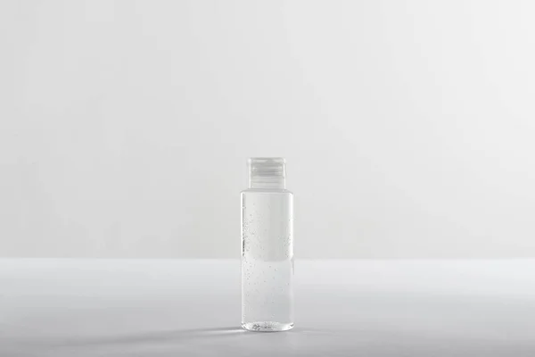 Косметическая бутылка с прозрачной жидкостью на белом фоне с копировальным пространством — стоковое фото