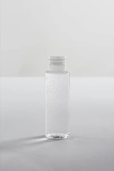 Transparent cosmetic bottle on white background with copy space — Stock Photo