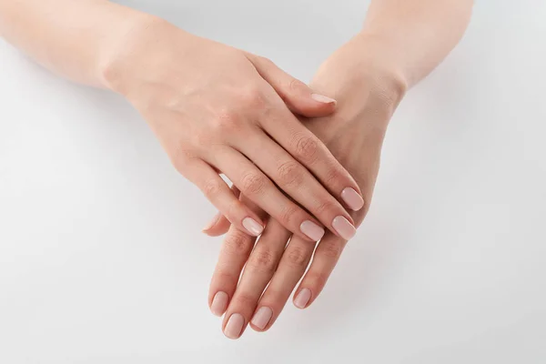 Partial view of female well-cared clanched hands on white background — Stock Photo