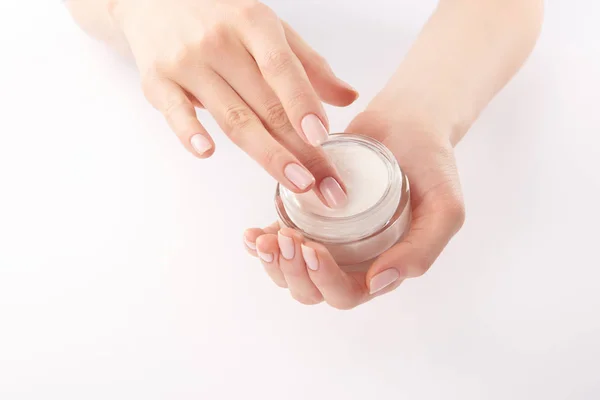 Vue partielle de la femme appliquant de la crème pour les mains sur fond blanc — Photo de stock