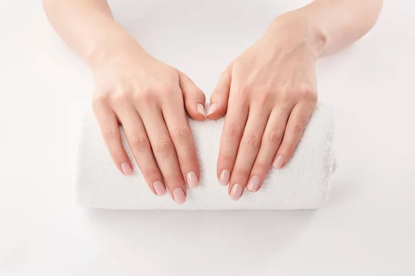Partial view of female hands on terry towel on white background — Stock Photo