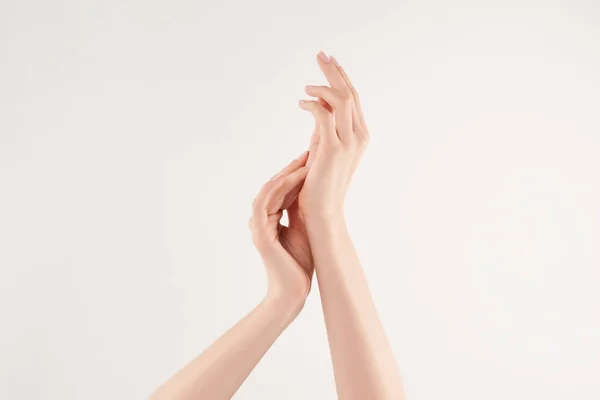 Vista parcial da mulher aplicando creme cosmético no fundo branco — Fotografia de Stock