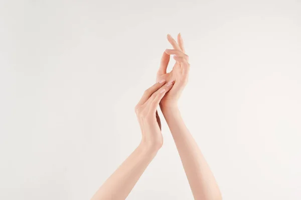 Vue partielle des mains féminines bien soignées sur fond blanc — Photo de stock