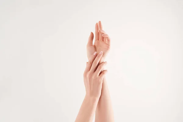 Vue partielle des mains féminines bien soignées sur fond blanc — Photo de stock