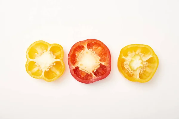 Studio shot of cut yellow and red bell peppers on white background — Stock Photo