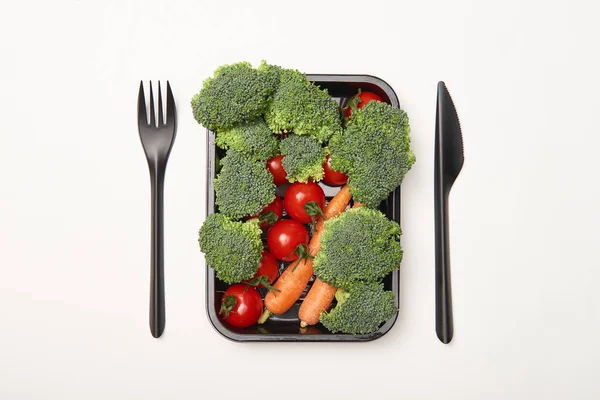 Вид сверху свежих овощей и посуды на белом фоне — стоковое фото