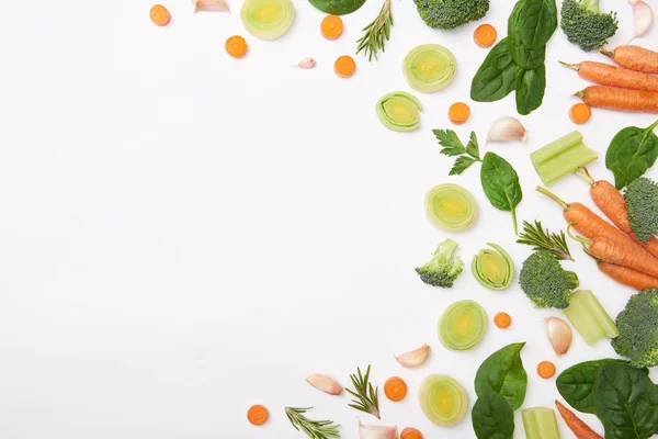 Posa piatta con verdure tagliate e foglie di spinaci su sfondo bianco — Foto stock