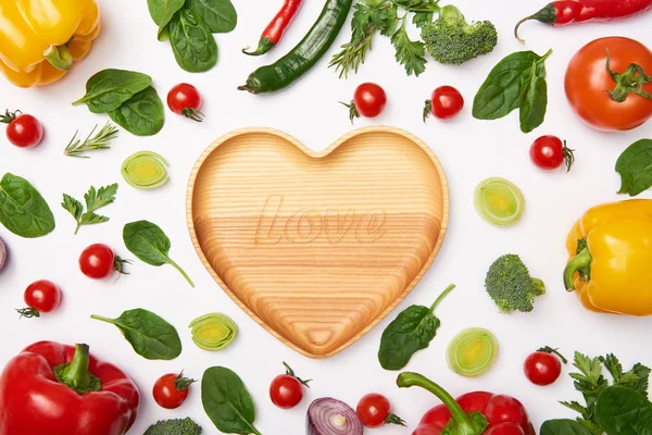 Asiento plano con verduras y tabla de cortar de madera sobre fondo blanco - foto de stock