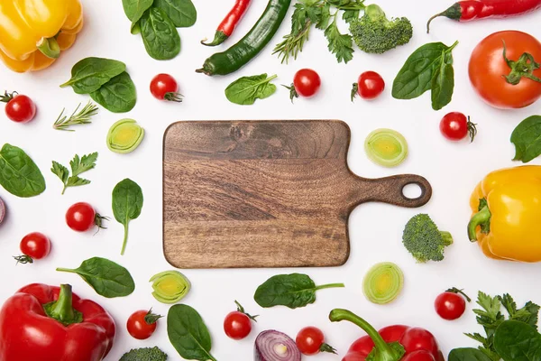 Asiento plano con verduras y tabla de cortar de madera sobre fondo blanco - foto de stock