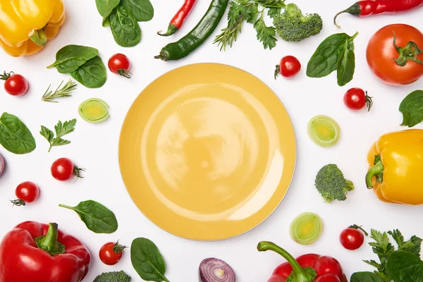 Acostado plano con plato amarillo y verduras sobre fondo blanco - foto de stock