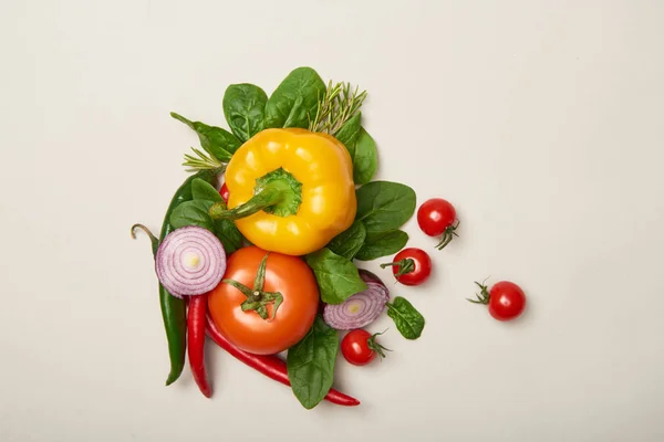 Вид зверху овочі та листя шпинату на сірому фоні — Stock Photo