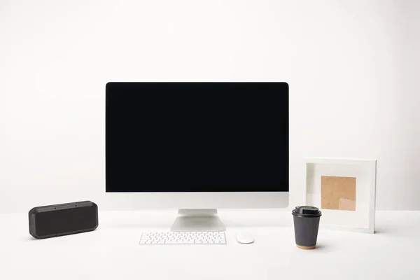 Lieu de travail avec café à emporter, haut-parleur portable et ordinateur de bureau avec espace de copie isolé sur blanc — Photo de stock