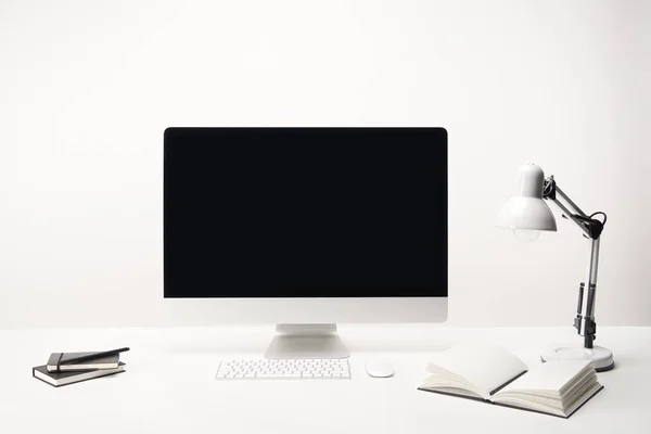 Lieu de travail avec lampe, ordinateurs portables et ordinateur de bureau avec espace de copie isolé sur blanc — Photo de stock