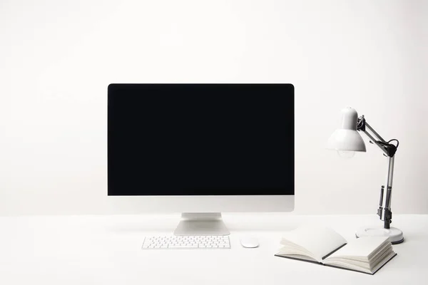 Lugar de trabajo con lámpara, portátil y computadora de escritorio con espacio de copia aislado en blanco - foto de stock