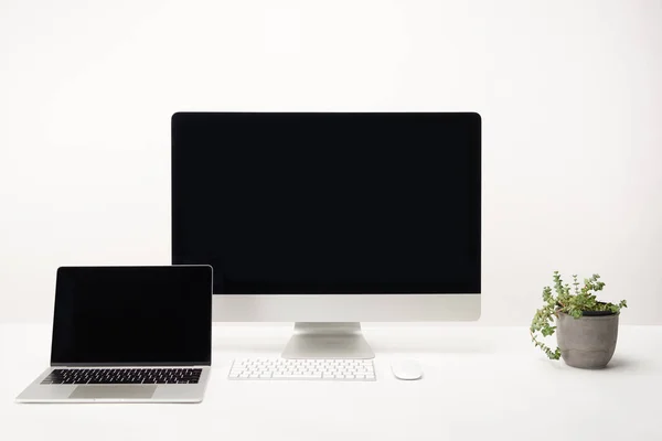 Lugar de trabajo con computadora de escritorio y portátil con espacio de copia aislado en blanco - foto de stock