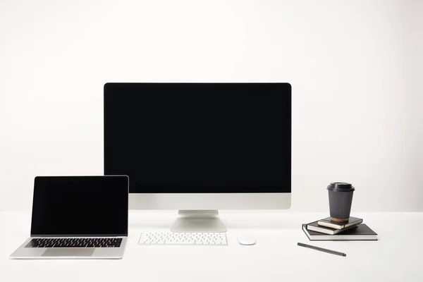 Lugar de trabajo con café para llevar, computadora de escritorio y computadora portátil con espacio de copia aislado en blanco — Stock Photo