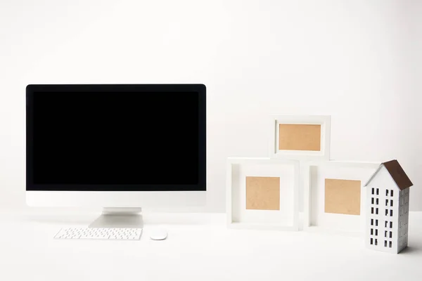 Lieu de travail avec cadres photo et ordinateur de bureau avec espace de copie isolé sur blanc — Photo de stock