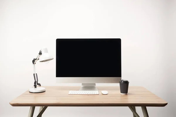 Lugar de trabajo con lámpara, café para llevar y computadora de escritorio con espacio de copia aislado en blanco — Stock Photo