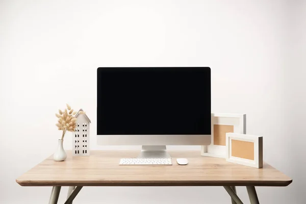 Lieu de travail avec cadres photo, fleurs sèches et ordinateur de bureau avec espace de copie isolé sur blanc — Photo de stock