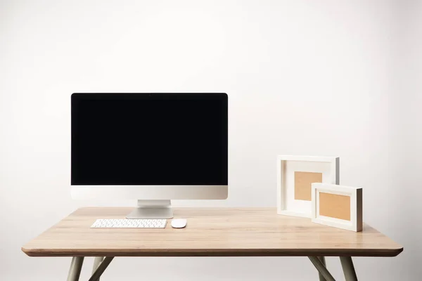 Workplace with photo frames and desktop computer with copy space isolated on white — Stock Photo