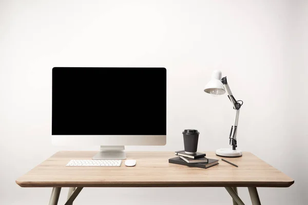 Workplace with lamp, coffee to go, notebooks and desktop computer with copy space isolated on white — Stock Photo