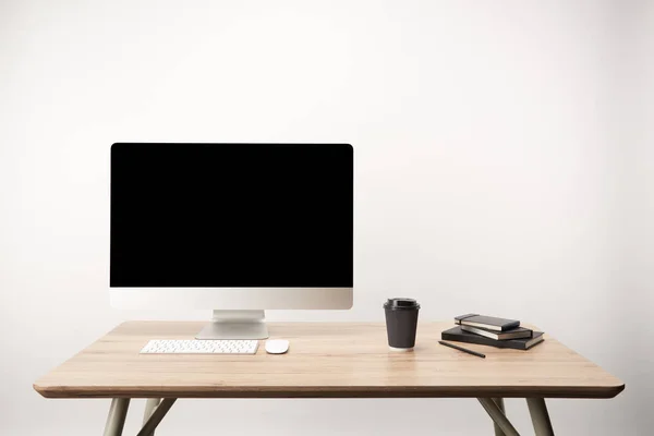 Lugar de trabajo con café para llevar, cuadernos y computadora de escritorio con espacio de copia aislado en blanco - foto de stock