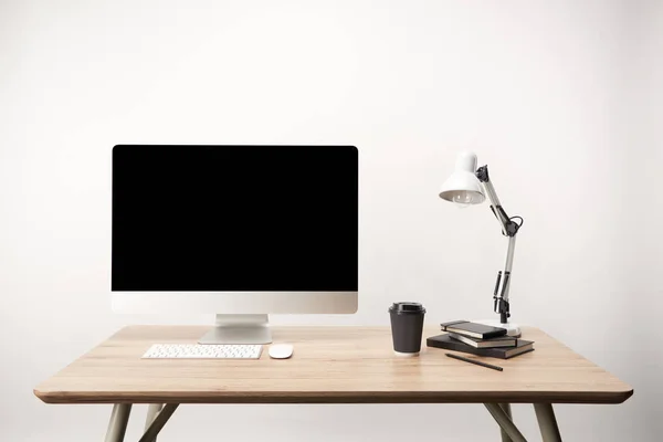 Workplace with lamp, coffee to go, notebooks and desktop computer with copy space isolated on white — Stock Photo