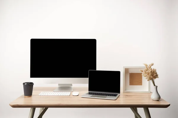 Arbeitsplatz mit Fotorahmen, Coffee to go, trockenen Blumen, Desktop-Computer und Laptop mit Kopierraum isoliert auf weiß — Stockfoto